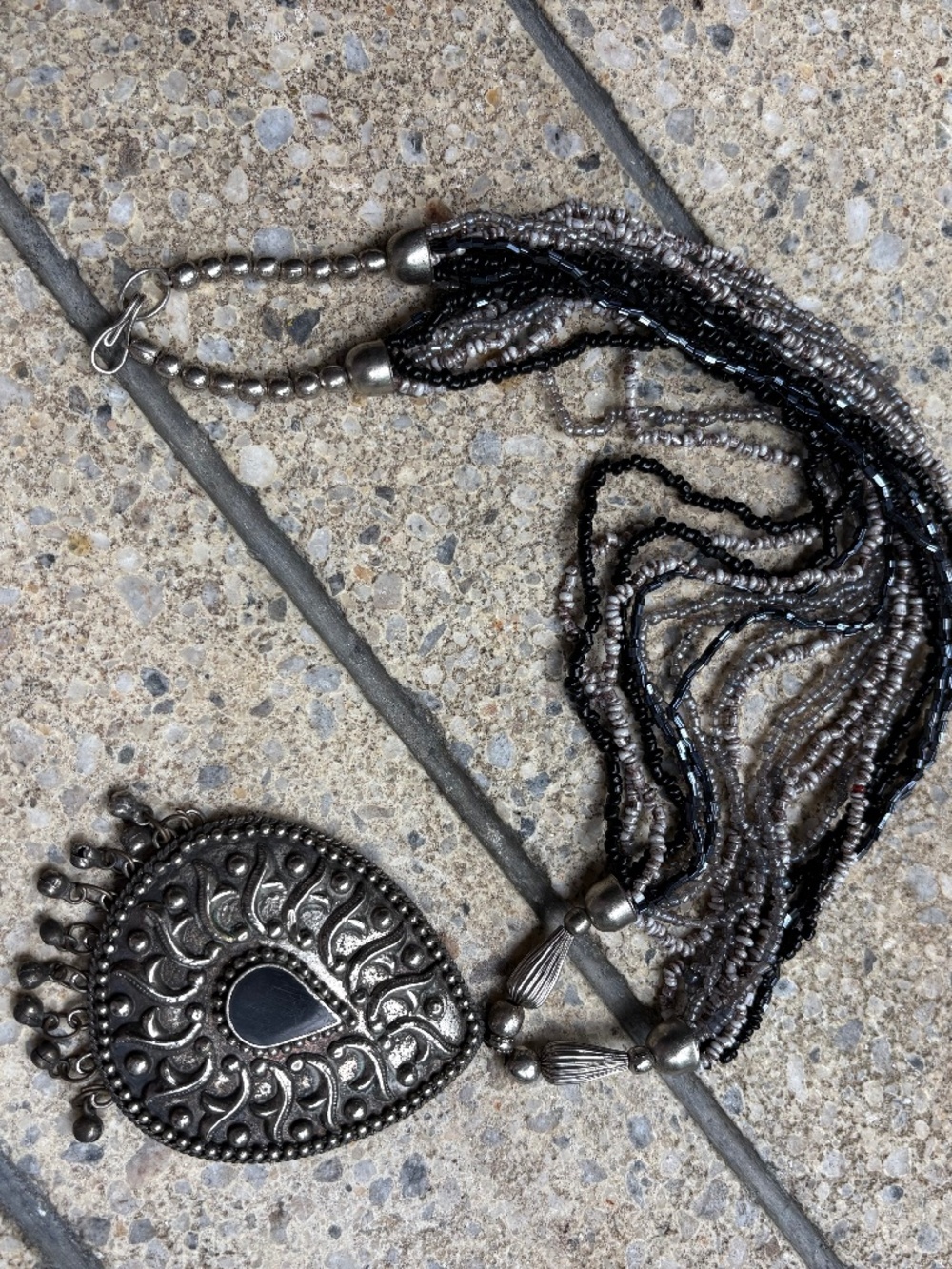 Silver tone pendant on beaded necklace
